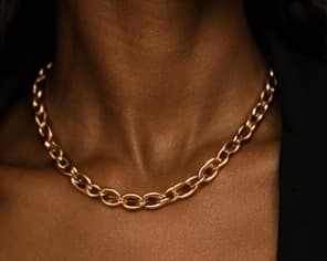Gold curb chain necklace, worn at the collarbone