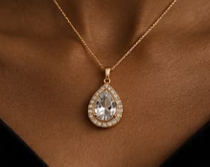 Teardrop stone pendant on a fine chain, worn at the collarbone