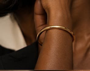 Smooth gold bangle, worn on the wrist