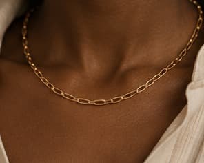 Gold paperclip chain necklace, worn at the collarbone