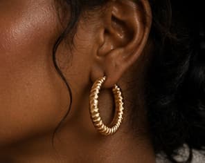Gold hoop earring, close-up on the ear