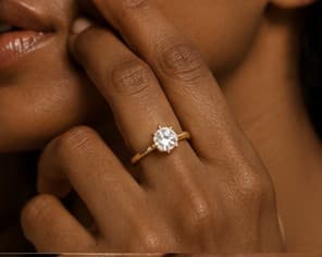 Gold solitaire ring, close-up on the hand