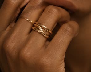 Stacked gold rings, close-up on the hand